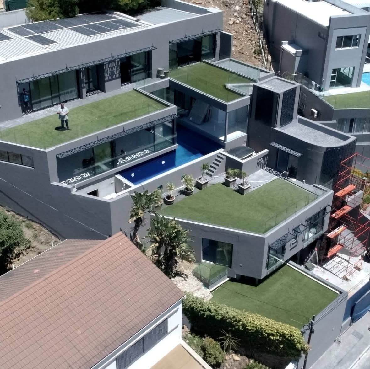 Aerial view of a modern home with rooftop garden and pool